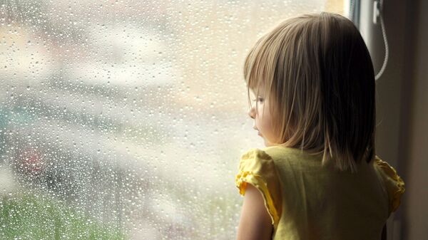 Девочка смотрит в окно. Архив