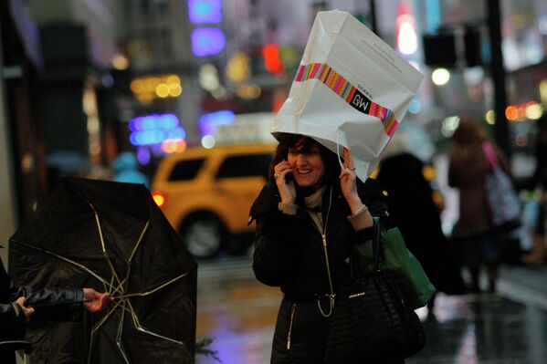 Женщина укрывается от дождя на Таймс-сквер в Нью-Йорке