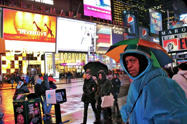 Люди укрываются от дождя на Таймс-сквер в Нью-Йорке
