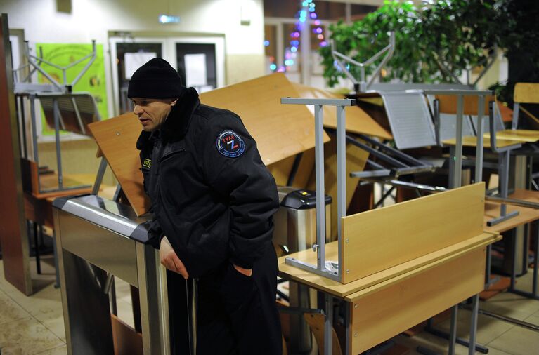 Сотрудник охраны у баррикад в фойе Российского государственного торгово-экономического университета в Москве Сотрудник охраны у баррикад в фойе Российского государственного торгово-экономического университета в Москве