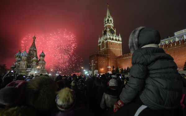 Москвичи и гости столицы, встречающие Новый Год на Красной Площади, наблюдают праздничный салют