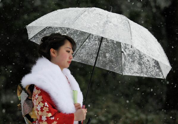 Девушка идет по улице во время снегопада, Япония