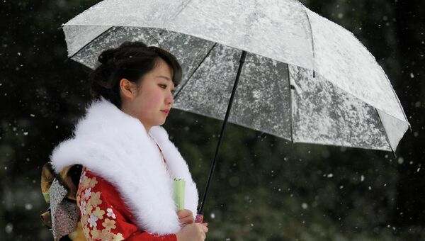 Девушка идет по улице во время снегопада, Япония