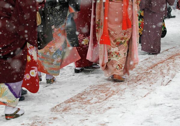 Девушки идут по улице во время снегопада в Токио