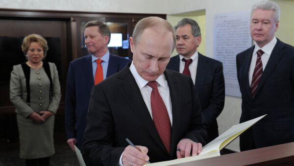 Владимир Путин делает запись в книге почетных гостей на открытии штаб-квартиры Русского географического общества