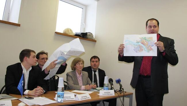 Представитель администрации города Алексей Логутов демонстрирует карту с местами высадок новых деревьев