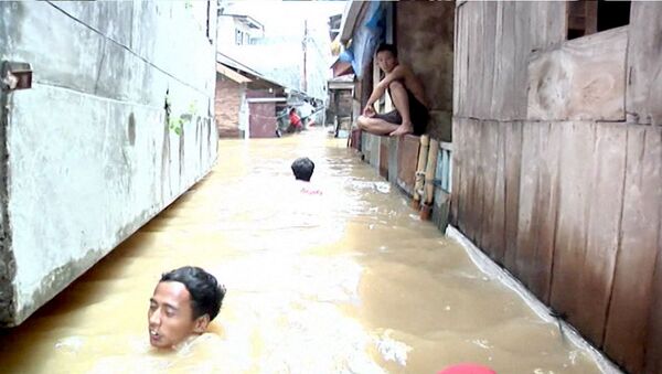 Люди по шею в воде передвигались по улицам Джакарты из-за наводнения