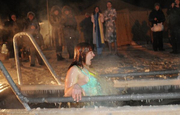 Женщина купается в проруби в праздник Крещения Господня в окресностях Читы
