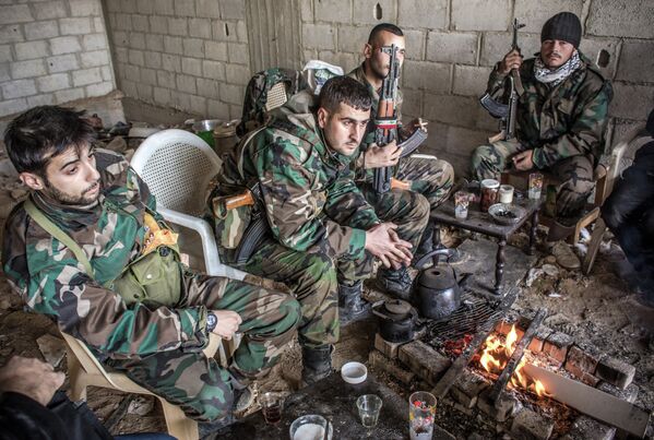 Военнослужащие сирийской армии отдыхают между боями с вооруженными экстремистами в городе Дарайя, Сирия