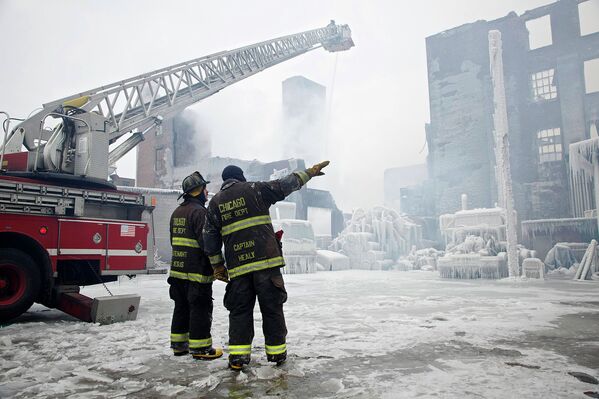 Пожарные у покрытого льдом здания складских помещений в Чикаго