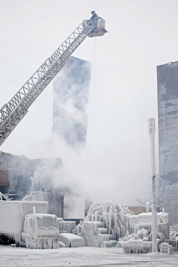 Пожарные тушат очаги возгорания в покрытом льдом здании складских помещений в Чикаго