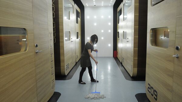 Уборщица моет пол в капсульной гостинице Sleepbox Hotel Tverskaya