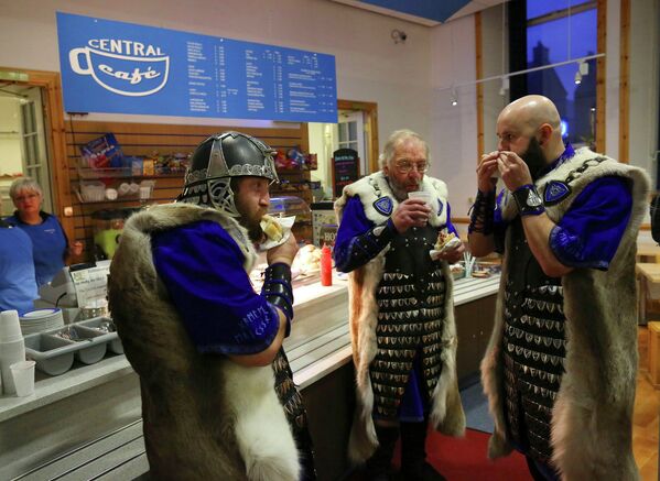 Мужчины в костюмах викингов принимают участие в фестивале Up Helly Aa в Леруике, Шотландские острова