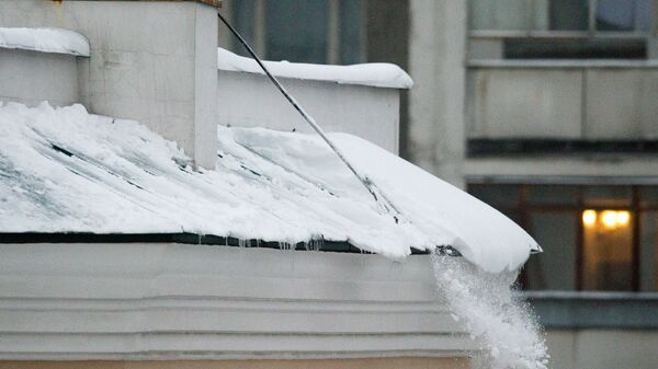 Падение снега с крыши дома. Архивное фото