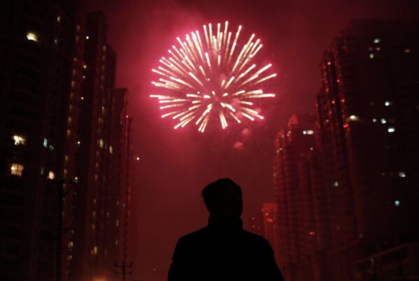 Мужчина смотрит салют в рамках празднования китайского Нового года в Шанхае