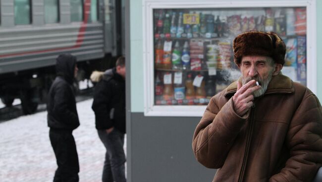 Мужчина курит на платформе железнодорожного вокзала Омска