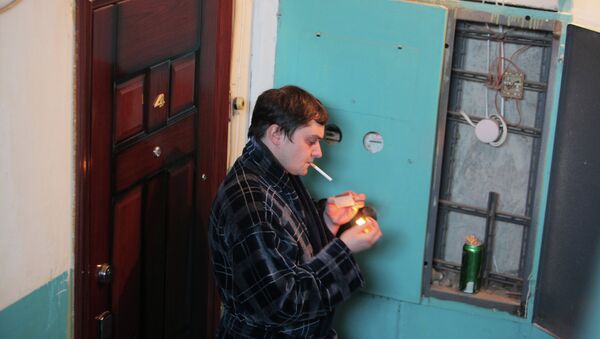 Мужчина курит в подъезде жилого дома. Архив
