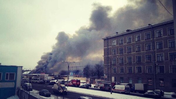 Черный дым поднимается над горящим ангаром в Петербурге