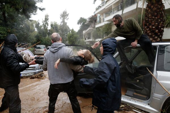 Оказание помощи пострадавшим от наводнения в пригороде Афин, Греция
