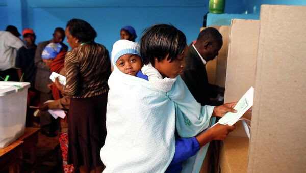 Женщина на избирательном участке в Кении