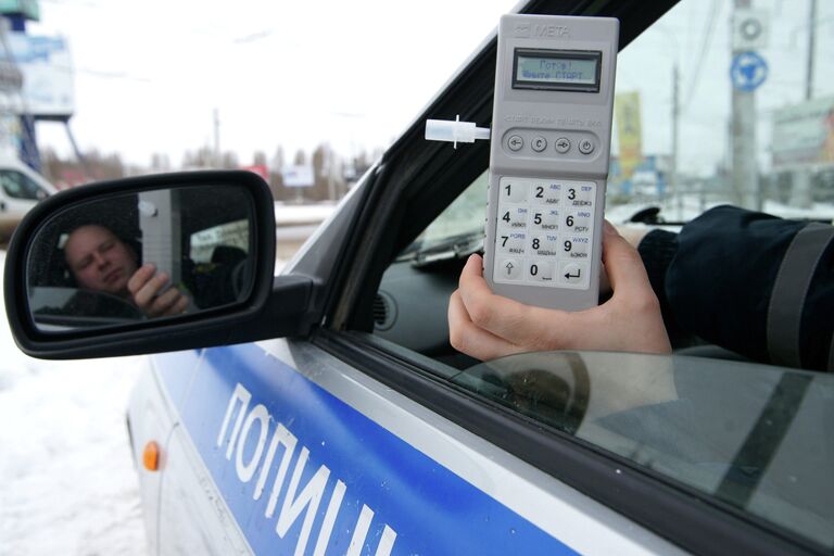 Сотрудник ГИБДД демонстрирует готовый к работе алкотестер Сотрудник ГИБДД демонстрирует готовый к работе алкотестер