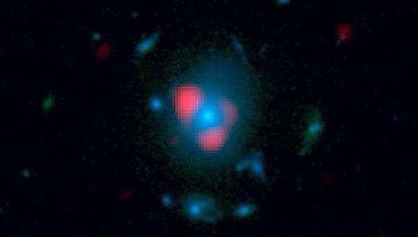 Одна из древних галактик, найденных телескопом ALMA, чей световой облик “растянут” и увеличен гравитационной линзой