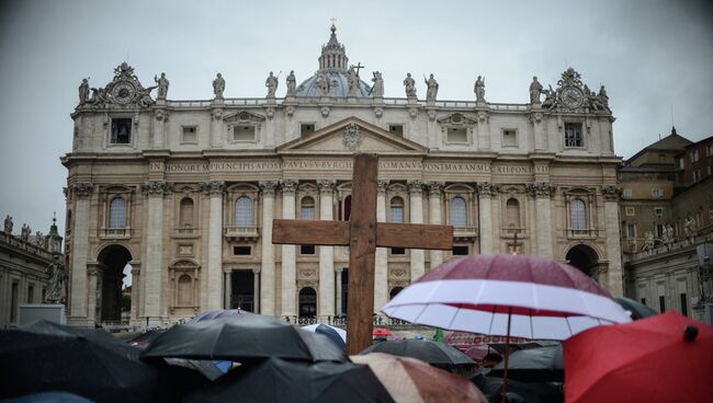 Верующие с крестом на площади у Апостольского дворца в Ватикане