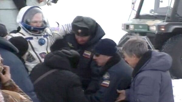 Прибывших с МКС космонавтов вынесли на руках из капсулы и закутали в пледы