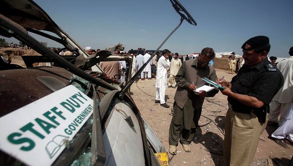 Сотрудники полиции работают на месте взрыва в лагере беженцев в Пакистане