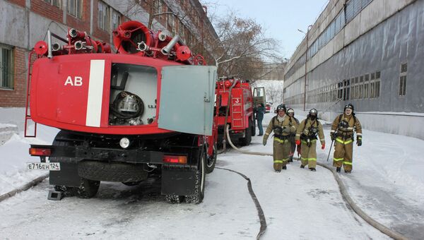 Сотрудники пожарной службы МЧС РФ на территории красноярского комбайнового завода, где произошел пожар