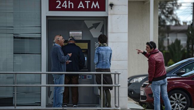 Жители Никосии стоят в очереди у банкомата Cyprus Popular Bank (CPB)