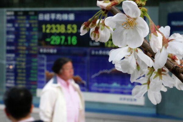 Цветущая сакура на фоне фондовой биржи в Токио