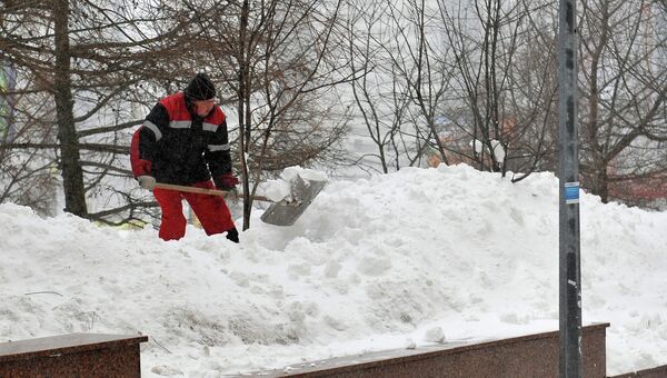 Сотрудник коммунальных служб убирает снег на одной из улиц Москвы