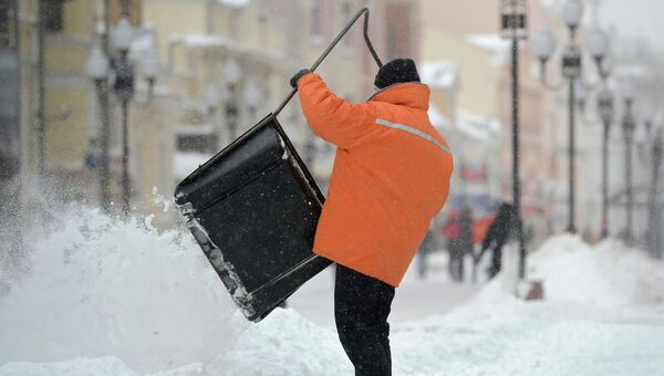 Работники коммунальных служб убирают снег после снегопада в Москве