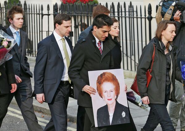Сторонники Маргарет Тэтчер несут портрет к ее дому в Великобритании