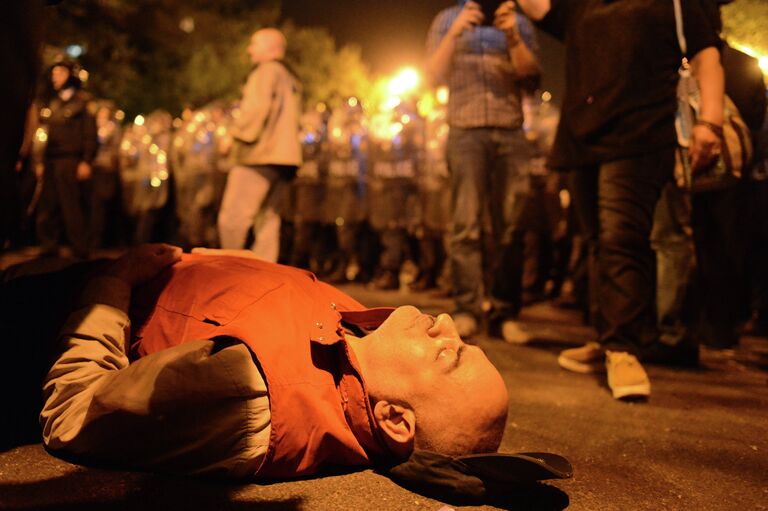 Участник шествия лежит на асфальте в знак протеста против результатов президентских выборов