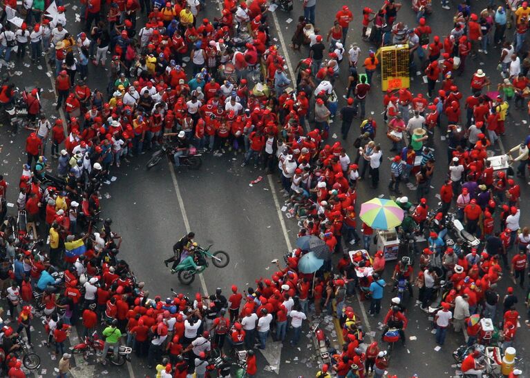 Сторонники Николаса Мадуро ожидают его прибытие на митинге в Каракасе