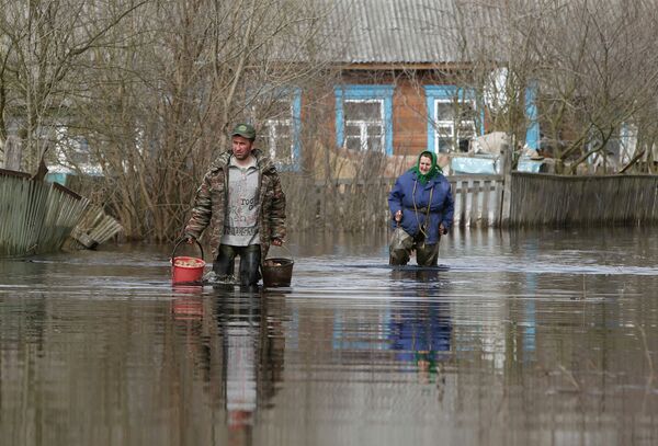 Жители деревни Озераны в Гомельской области идут по затопленной паводком улице