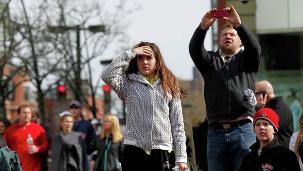 Прохожие наблюдают за ситуацией после взрыва в Бостоне