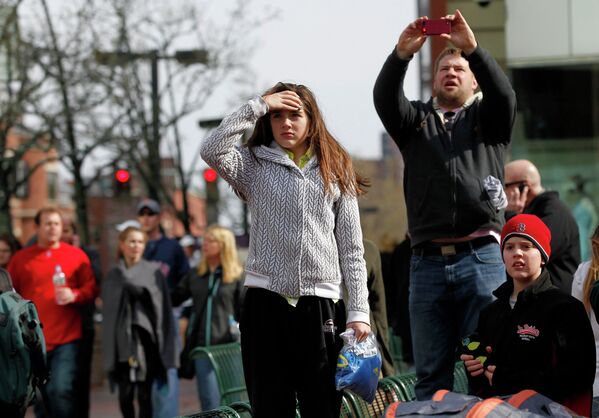 Прохожие наблюдают за ситуацией после взрыва в Бостоне
