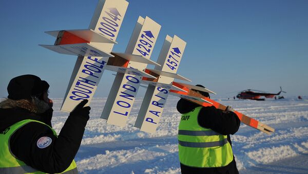 Сотрудники дрейфующей ледовой базы Барнео, находящейся в Арктике, несут символический указательный столб. Архивное фото