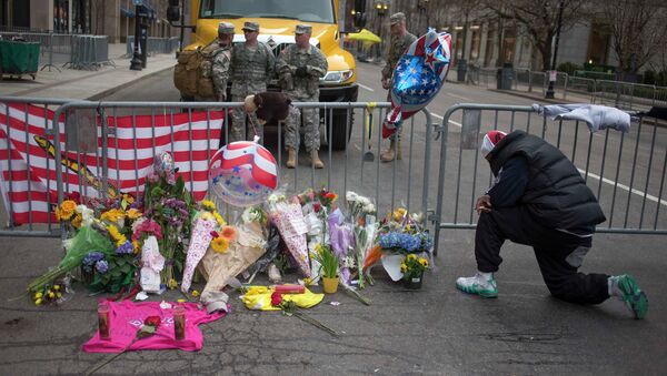 Люди несут цветы в память о погибших в Бостоне