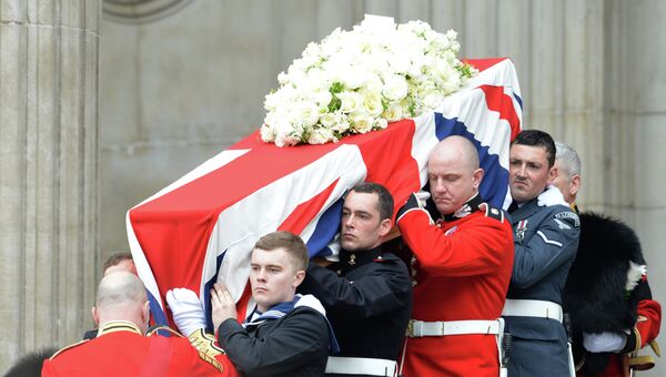 Гроб с телом экс-премьера Великобритании Маргарет Тэтчер, накрытый государственным флагом, выносят из собора Святого Павла,