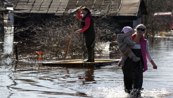Жители города Тосно Ленинградской области на затопленной в результате паводка улице