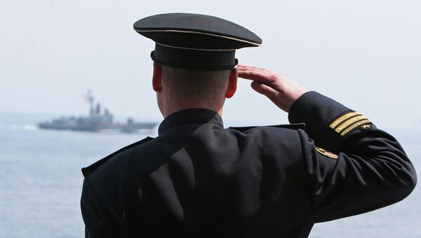 Вахтенный офицер отдает воинское приветствие проходящему судну во время проведения учений. Архивное фото