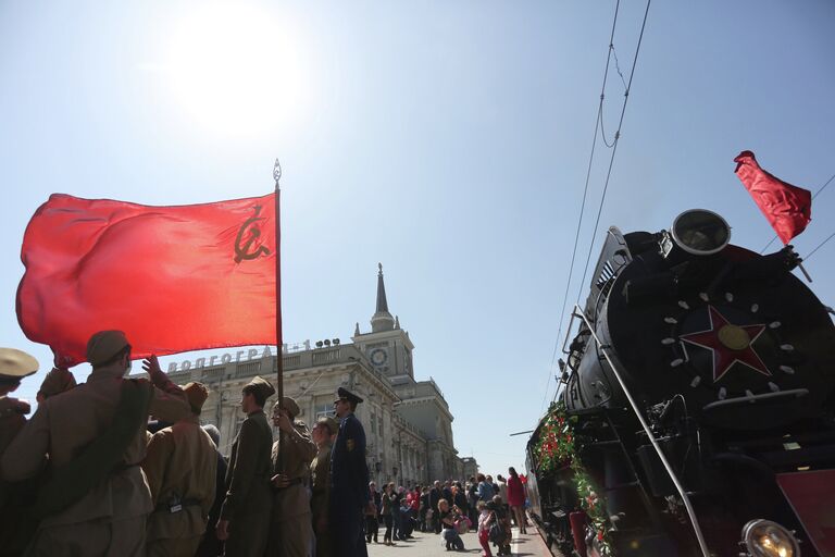 Молодые люди в военной форме времен Великой Отечественной войны стоят у ретро-поезда Победа