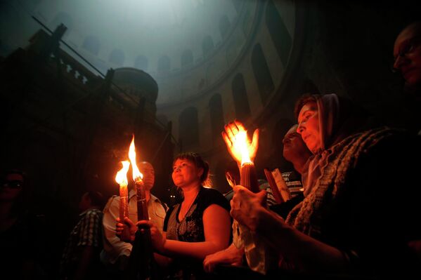 Верующие во время церемонии схождения Благодатного огня в храме Гроба Господня в Иерусалиме