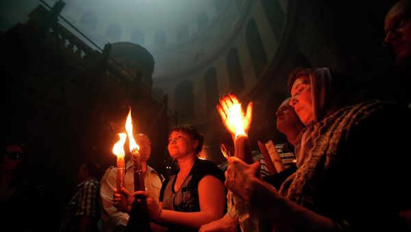 Верующие во время церемонии схождения Благодатного огня в храме Гроба Господня в Иерусалиме