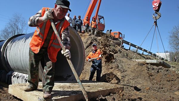 Рабочие восстанавливают мост, разрушенный паводковыми водами в деревне Подпорино Истринского района Московской области