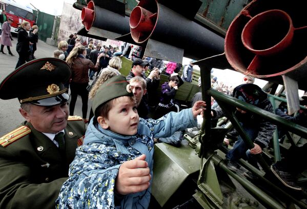 Офицер с внуком у боевой машины БМ-32 после военного парада